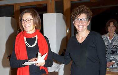 F. Franceschi (ass. cultura comune di Primiero) premia Daria De Pellegrini